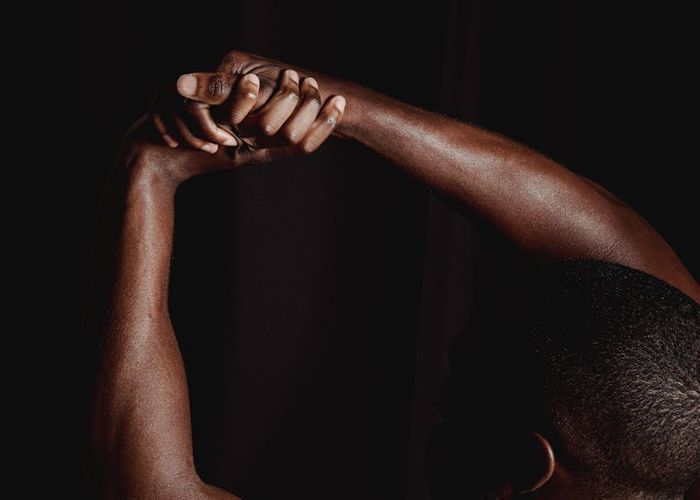 Man stretching his arms in a modern dark interior